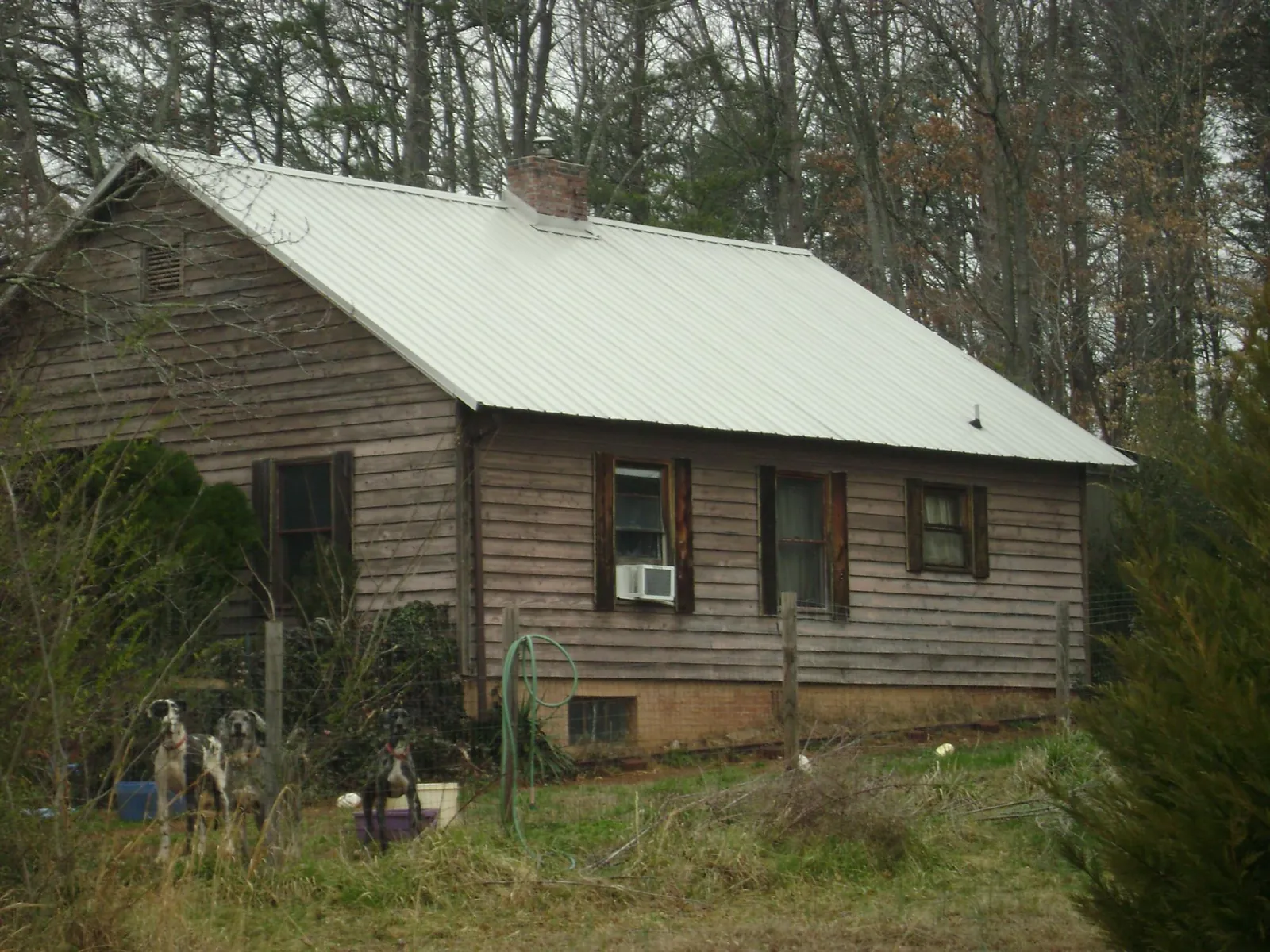 White metal roof on an old wood sided farmhouse, from a Metal Roof Installation job in Seward